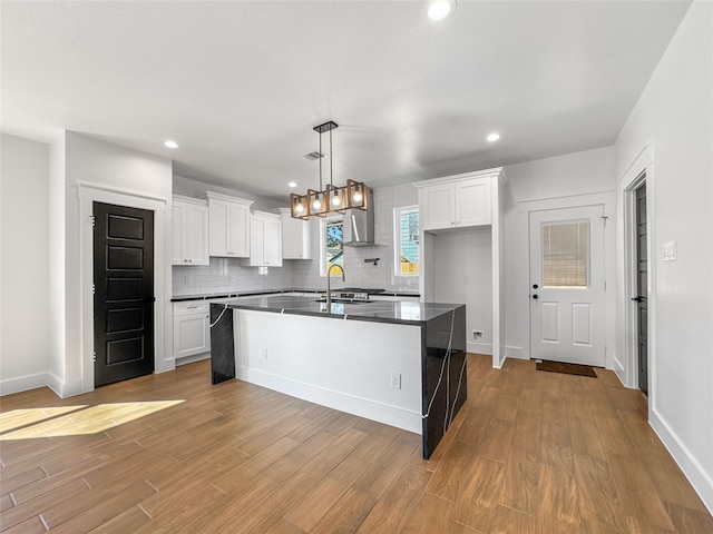 kitchen featuring backsplash, dark countertops, wood finished floors, and white cabinetry