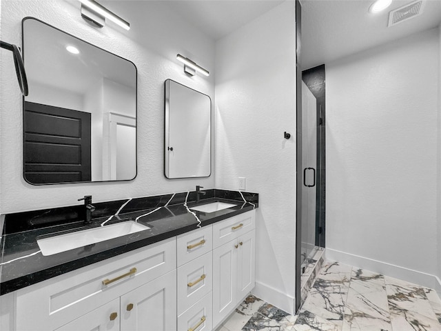 full bathroom featuring marble finish floor, a stall shower, a sink, and baseboards