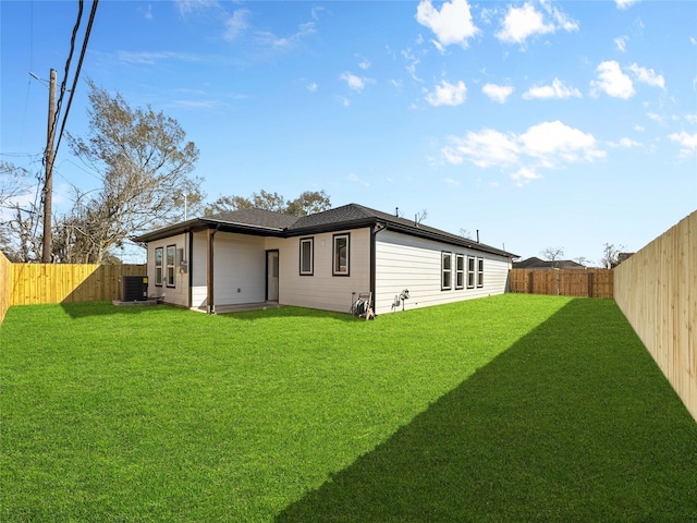 rear view of house featuring a fenced backyard, cooling unit, and a yard