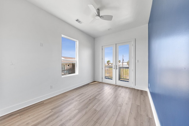 spare room featuring visible vents, baseboards, a ceiling fan, french doors, and light wood-type flooring