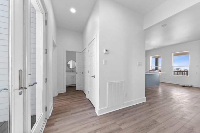 corridor with recessed lighting, visible vents, light wood-style flooring, and baseboards