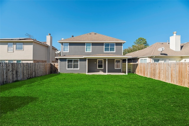 rear view of house featuring a patio area, a fenced backyard, and a yard