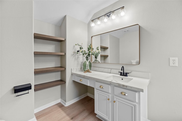 bathroom featuring visible vents, wood finished floors, vanity, and baseboards