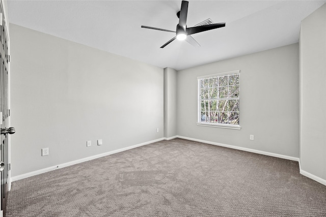 carpeted spare room with ceiling fan and baseboards