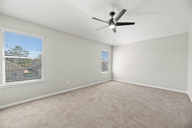 empty room featuring a ceiling fan, baseboards, a healthy amount of sunlight, and carpet flooring