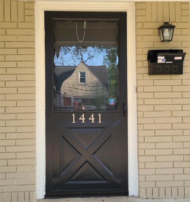 doorway to property with brick siding