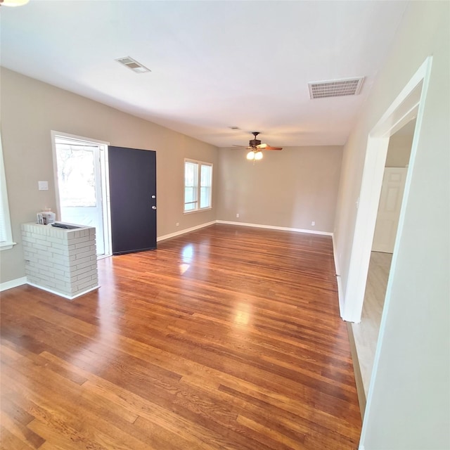 interior space with ceiling fan, visible vents, and wood finished floors