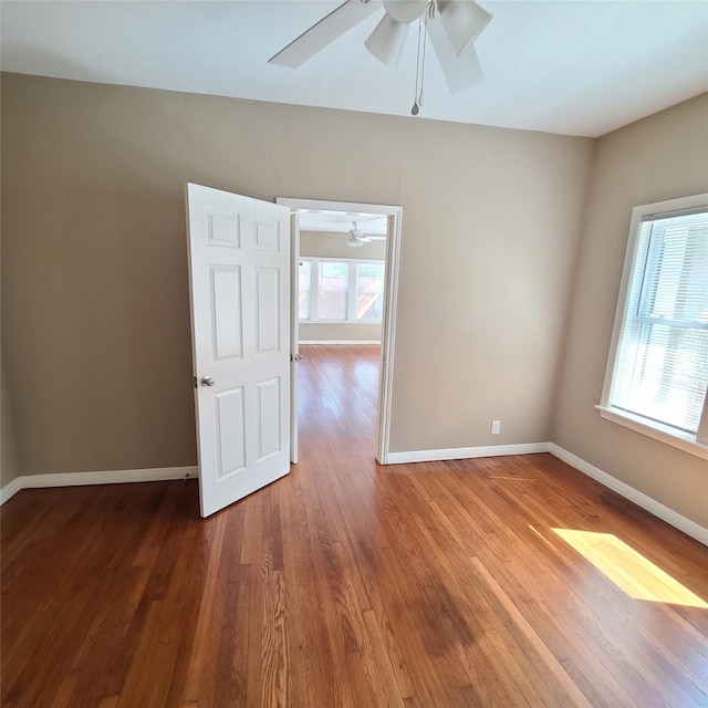 spare room with ceiling fan, baseboards, and wood finished floors