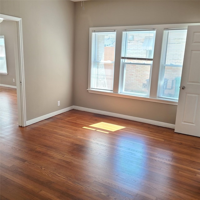 empty room featuring baseboards and wood finished floors