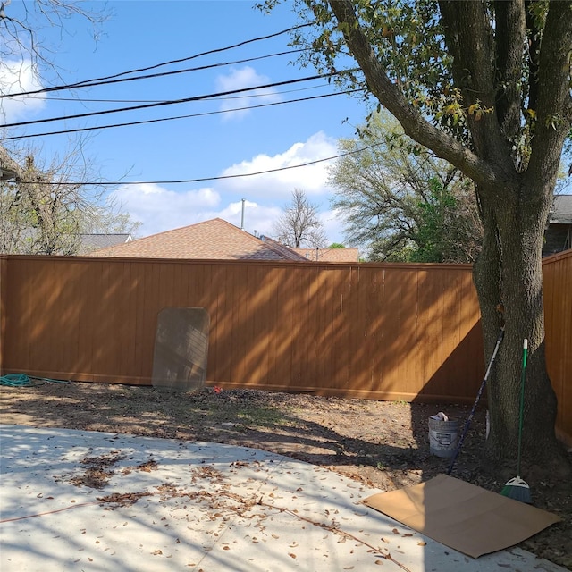 view of home's exterior featuring a shingled roof and fence