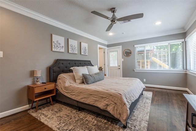 bedroom with dark wood-style flooring, visible vents, crown molding, and baseboards