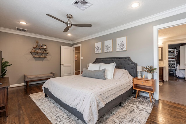 bedroom with visible vents, dark wood finished floors, and crown molding