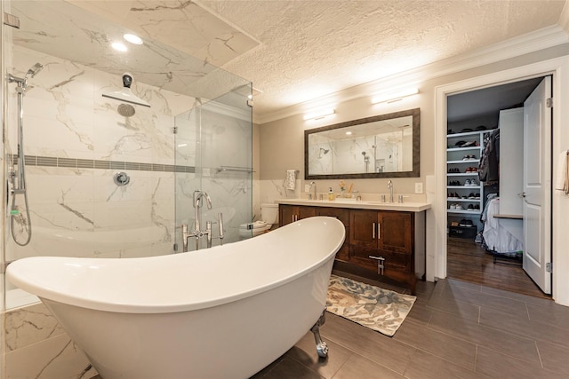 bathroom with a marble finish shower, ornamental molding, a textured ceiling, and vanity