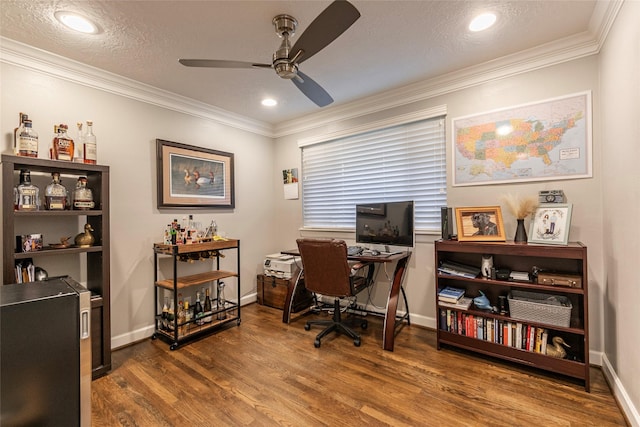 office area featuring baseboards, crown molding, a ceiling fan, and wood finished floors