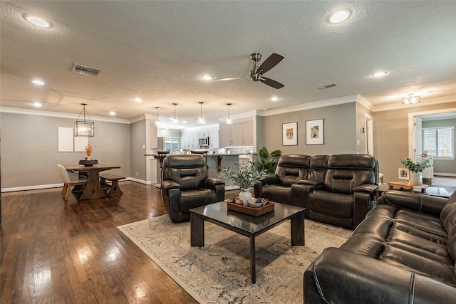 living area featuring visible vents, crown molding, and wood finished floors