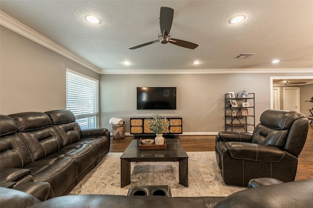 living room featuring a textured ceiling, wood finished floors, visible vents, a ceiling fan, and ornamental molding