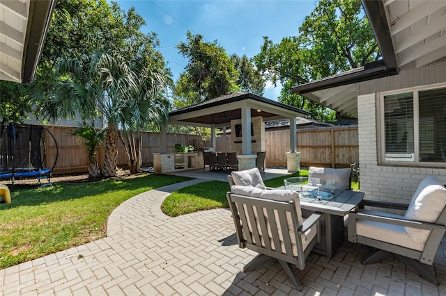 view of patio / terrace with a trampoline, outdoor dining area, and a fenced backyard