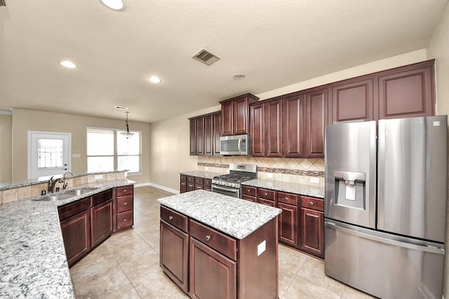 kitchen with light tile patterned floors, a sink, visible vents, appliances with stainless steel finishes, and tasteful backsplash