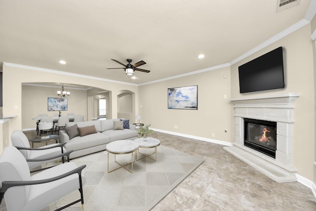 living area with ornamental molding, a glass covered fireplace, visible vents, and baseboards