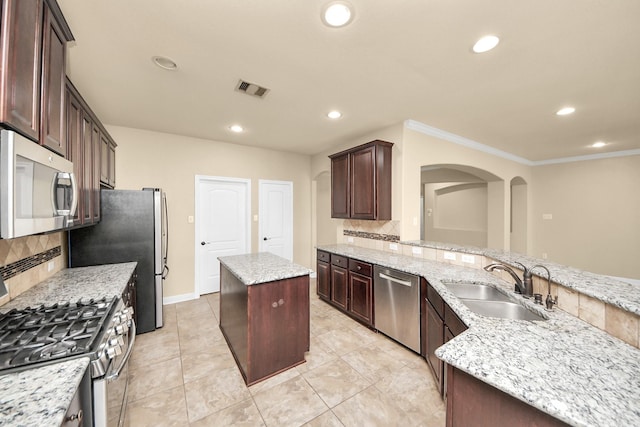 kitchen with stainless steel appliances, a sink, a center island, and recessed lighting