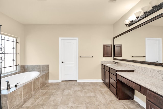 full bathroom featuring tile patterned flooring, a garden tub, vanity, and baseboards