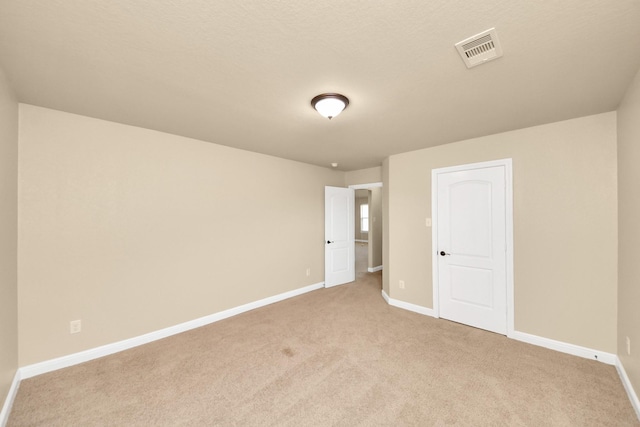 interior space with light colored carpet, visible vents, and baseboards