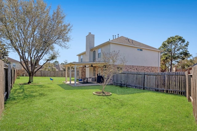 view of yard with a ceiling fan, a patio area, and a fenced backyard