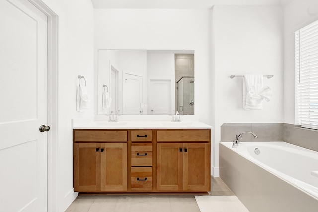 bathroom featuring a stall shower, double vanity, a sink, and a bath