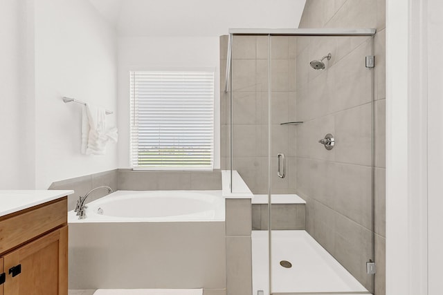 bathroom featuring a stall shower, vanity, and a bath