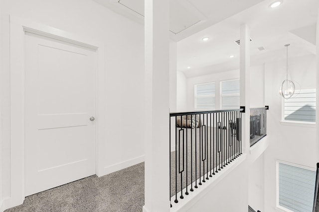 corridor with carpet floors, recessed lighting, an upstairs landing, a chandelier, and baseboards