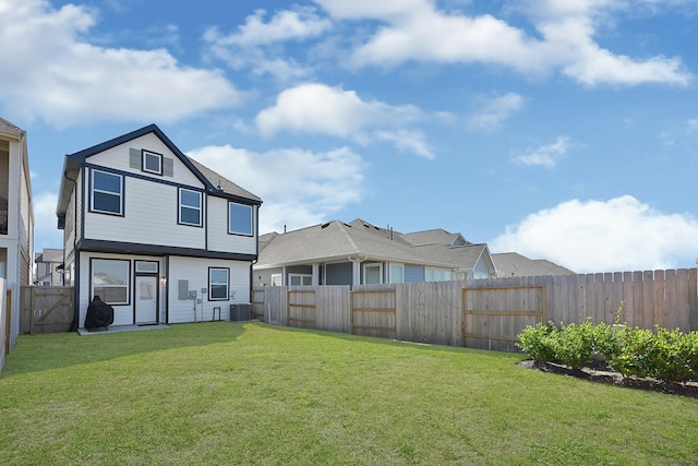 rear view of property with a fenced backyard, a lawn, and central AC unit