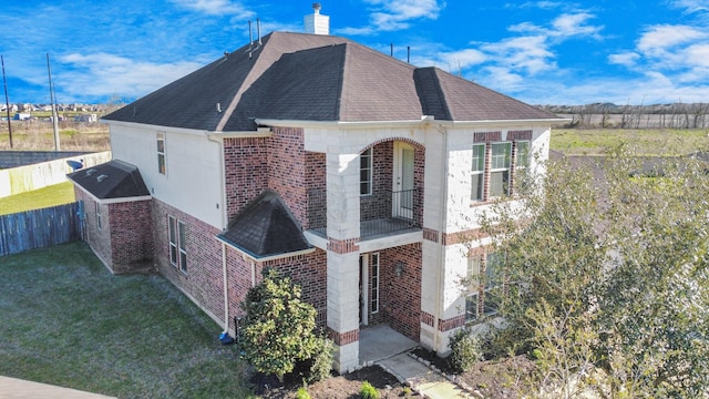 view of property exterior featuring brick siding, a shingled roof, fence, a lawn, and a chimney