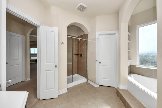 bathroom featuring a stall shower, plenty of natural light, and visible vents