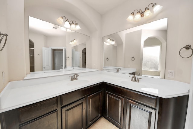 full bath with double vanity, tile patterned flooring, and a sink