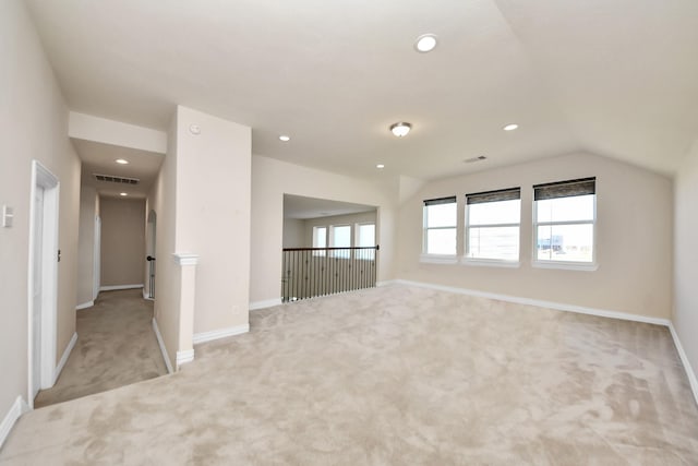 carpeted empty room featuring vaulted ceiling, baseboards, visible vents, and recessed lighting