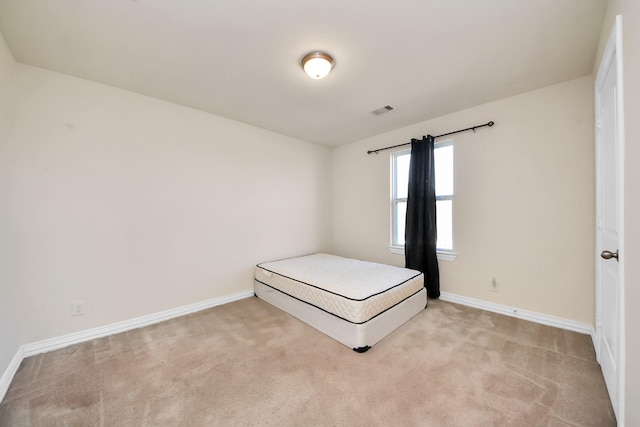 unfurnished bedroom with baseboards, visible vents, and light colored carpet