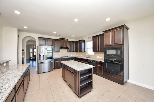 kitchen with arched walkways, dark brown cabinetry, open shelves, a sink, and black appliances