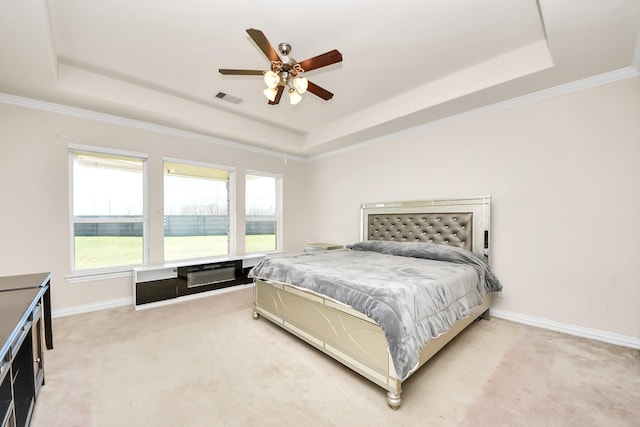 bedroom with baseboards, a tray ceiling, visible vents, and light colored carpet