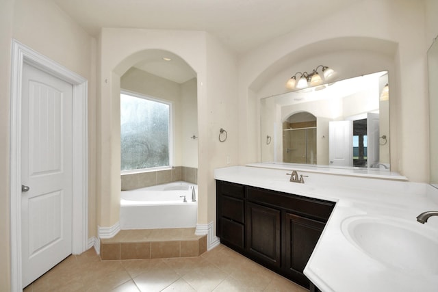 full bath featuring a garden tub, a sink, a shower stall, and double vanity