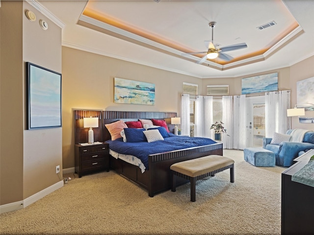 bedroom featuring visible vents, light colored carpet, a tray ceiling, and ornamental molding