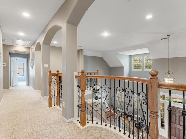 hallway with an upstairs landing, recessed lighting, arched walkways, carpet floors, and baseboards