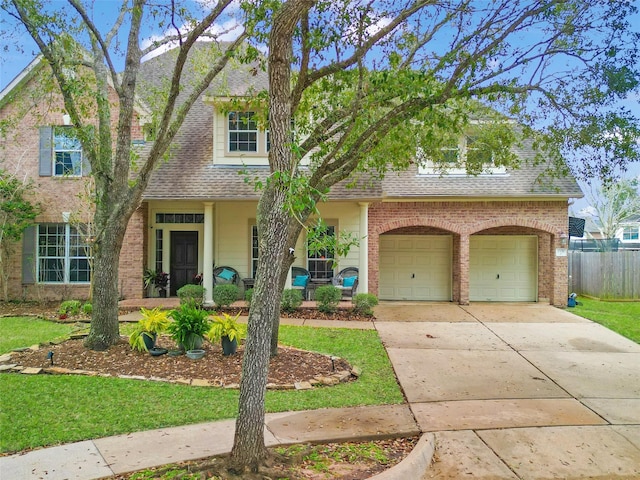 view of front of property with fence, brick siding, driveway, and roof with shingles