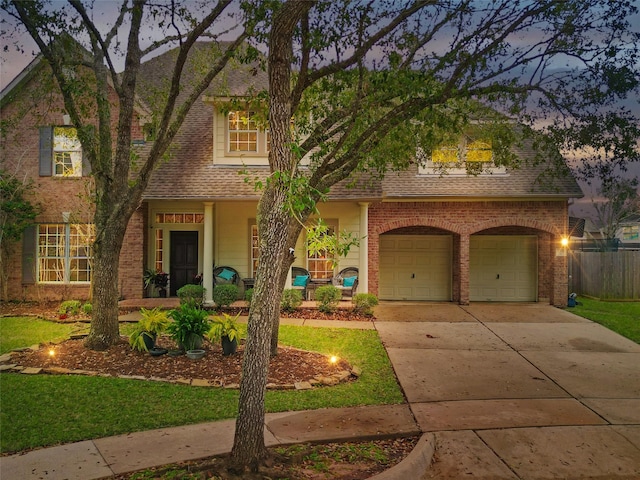 view of front facade featuring brick siding, driveway, and a shingled roof