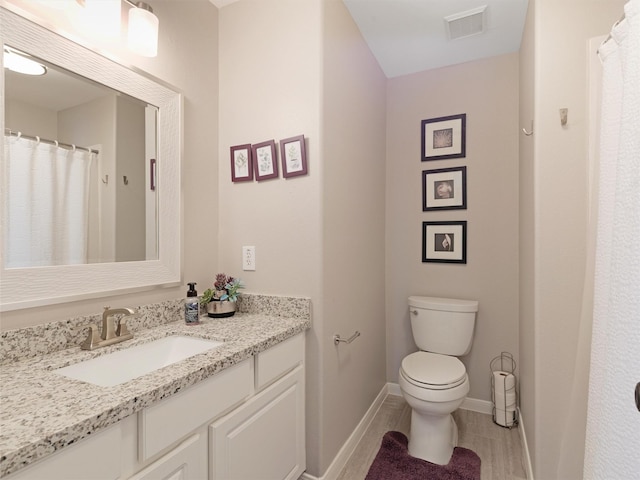 full bathroom with visible vents, baseboards, toilet, and vanity