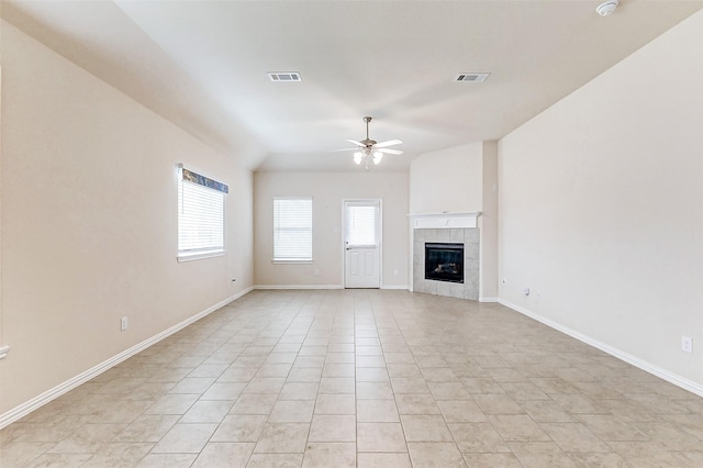 unfurnished living room featuring visible vents, ceiling fan, a tiled fireplace, and light tile patterned floors