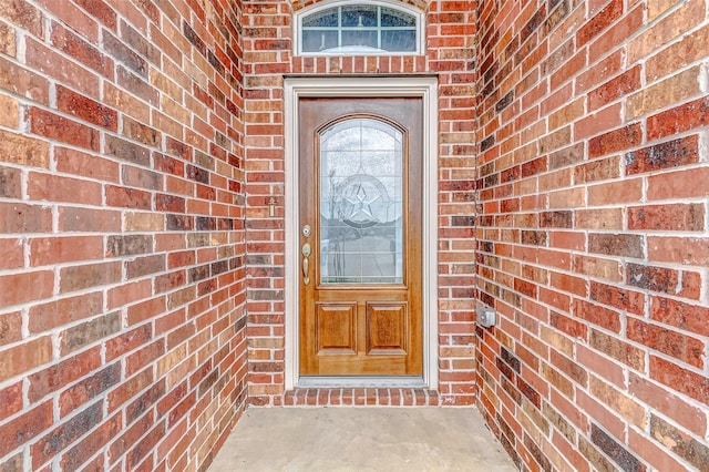 entrance to property featuring brick siding