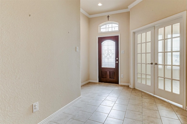 entrance foyer with ornamental molding, french doors, light tile patterned flooring, and baseboards