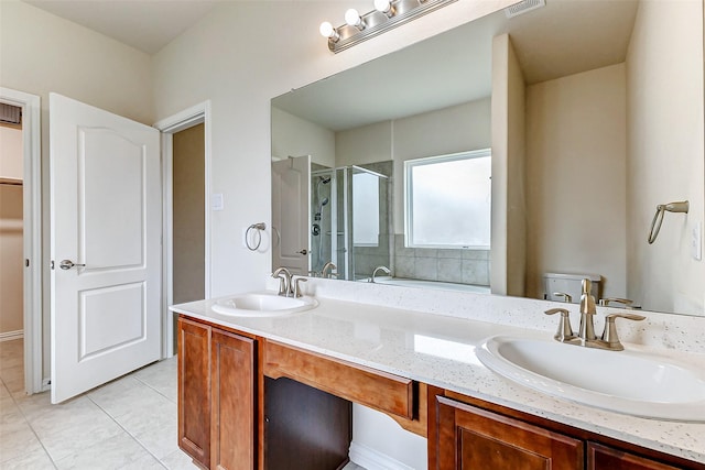 full bathroom with double vanity, tile patterned flooring, a sink, and a shower stall