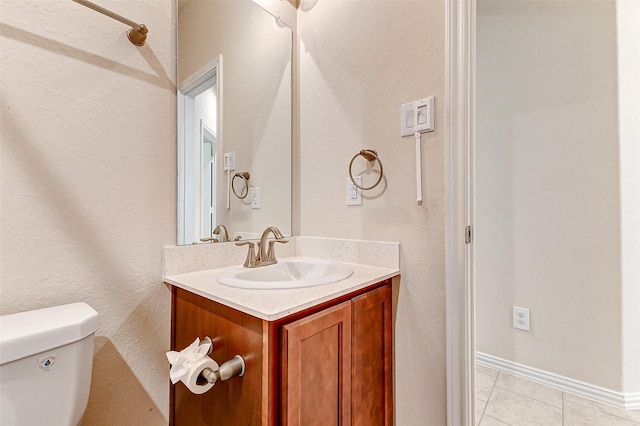 bathroom featuring toilet, baseboards, vanity, and tile patterned floors