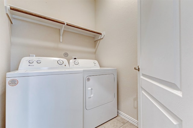 laundry room featuring washer and dryer, laundry area, baseboards, and light tile patterned floors